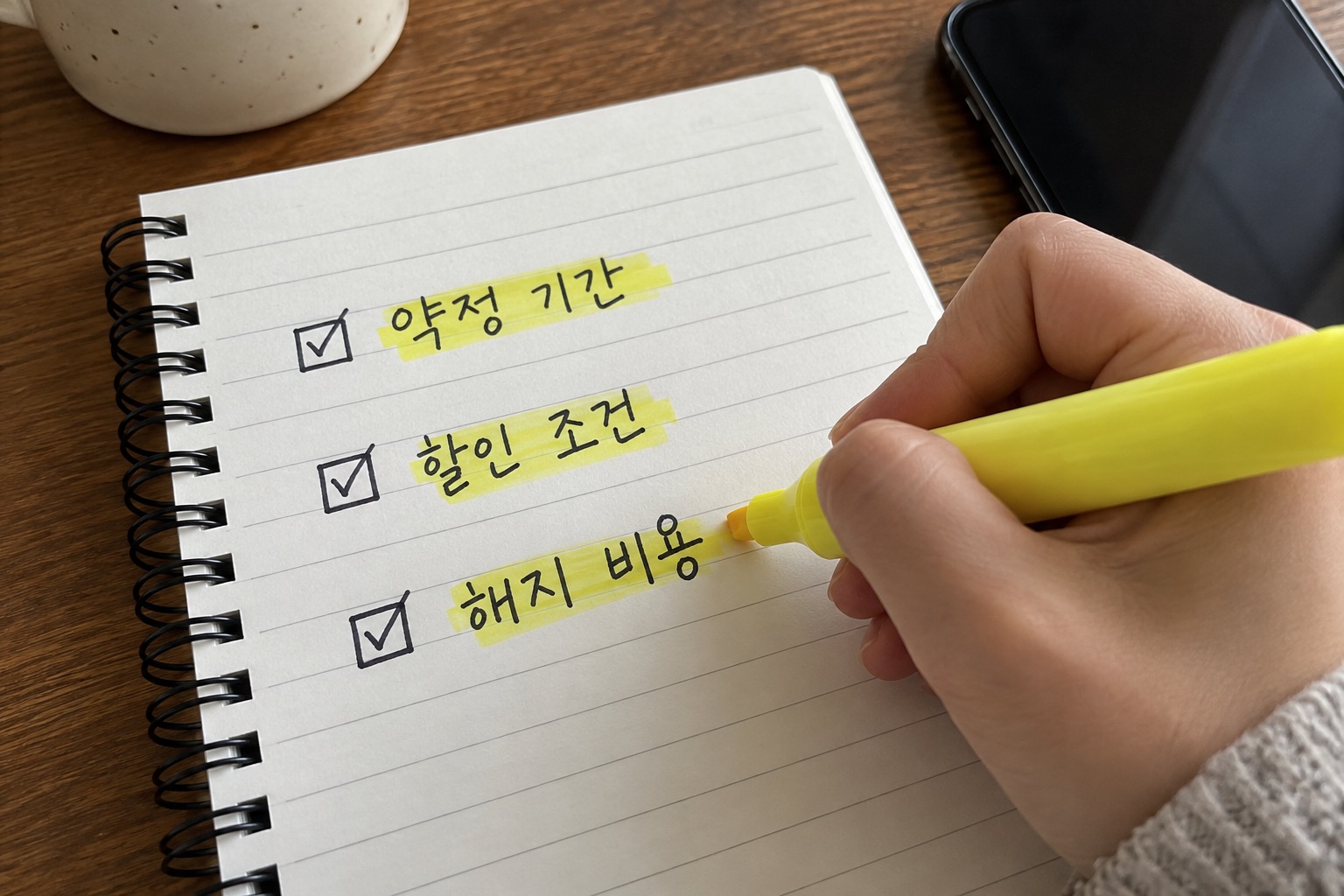 휴대전화 가입 조건을 메모와 함께 비교하는 모습